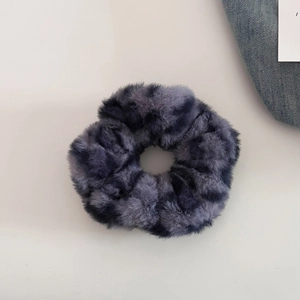 Close-up of plush leopard print scrunchie with soft grey and black faux fur texture