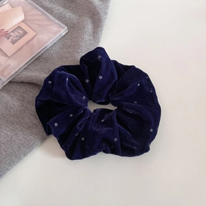Dettaglio dell'elastico in velluto blu scuro con pois argentati e texture morbida