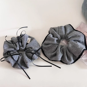 Elegant grey knitted hair scrunchies set with black bow accents and handmade label