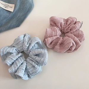 Close-up of hollow lace scrunchies in blue and pink with elegant mesh texture detail