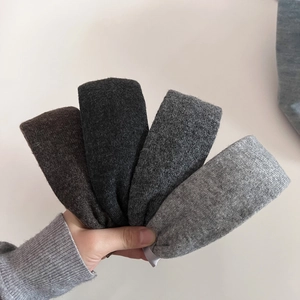Close-up of assorted knit headbands in five shades of grey and black textured wool fabric