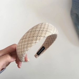 Close-up of beige plaid tweed padded headband featuring a handmade inner label detail