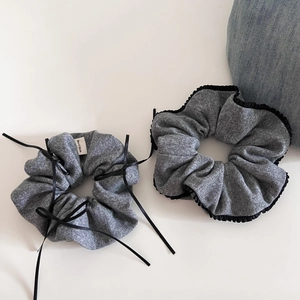 Detail showing grey knit scrunchies with black bows and ruffled lace edges