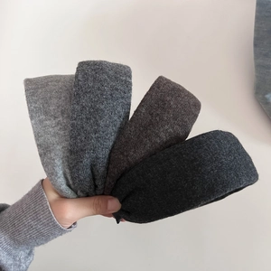 Detail showing textures of four knitted headbands in grey, coffee and black colors