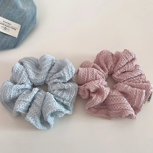 Detail of light blue and pink lace scrunchies showing fine knit hollow texture
