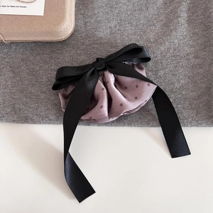 Detail of French polka dot ribbon bow hair clip with smooth satin texture and elegant style