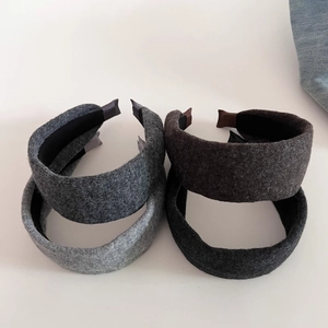 Close-up of four thick knitted wide headbands in grey and brown for autumn and winter