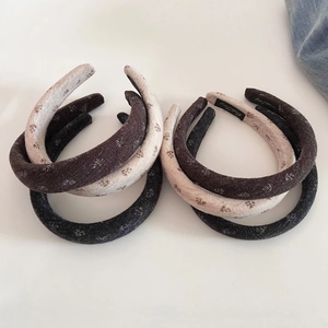 Detail view of knitted sponge headbands with delicate floral embroidery in three colors