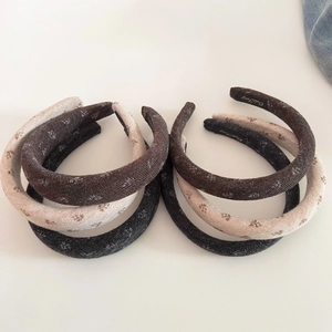 Detailed view of textured floral knit sponge headbands in various vintage neutral colors