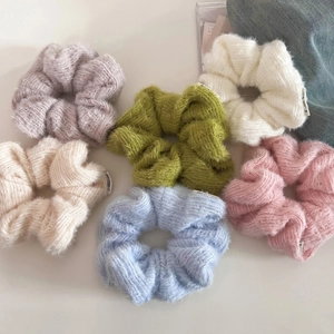Detail of six colorful fuzzy knit scrunchies in pastel tones with soft mohair texture