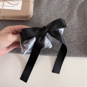 Detail of French polka dot satin bow hair clip with layered black and grey ribbons