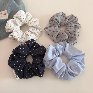 Détail de quatre chouchous aux motifs floraux et à pois avec étiquette en tissu