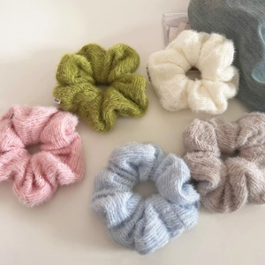 Detailed close-up of colorful knit scrunchies in five soft Morandi shades on white background