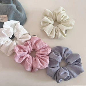 Close-up of four colorful bubble knit scrunchies with soft waffle texture fabric
