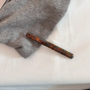 Macro detail of tortoiseshell acetate barrette with gold Barrette La France lettering