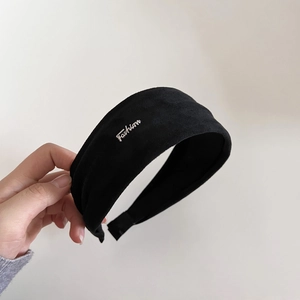 Détail d'un serre-tête en daim noir avec ornement en lettres métalliques Fashion
