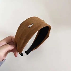 Vue détaillée du serre-tête en daim marron avec détail métal Fashion et doublure antidérapante
