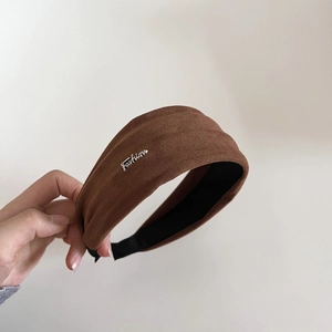 Détail d'un serre-tête en daim marron avec lettres métalliques Fashion argentées