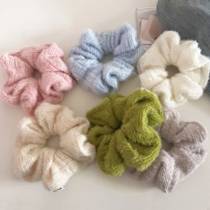 Close-up of colorful knitted scrunchies set in soft wool texture for hair styling