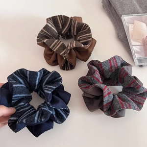 Three-pack of striped knit scrunchies in brown, navy, and grey for women's hair
