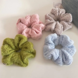 Colorful knitted wool scrunchies in pink, gray, green and blue for autumn and winter style