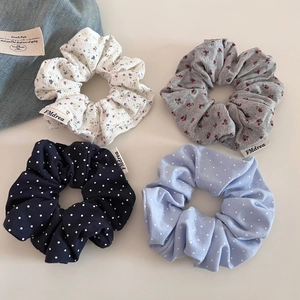 Vue à plat de quatre chouchous à fleurs et pois avec étiquettes de marque blanches