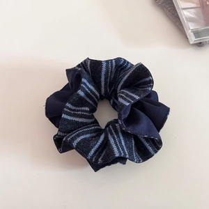 Detail of navy blue satin and striped knit patchwork oversized scrunchie hair tie