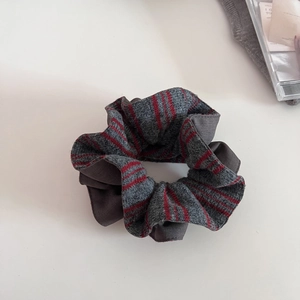 Detail of soft dark grey knitted scrunchie with red stripes for hair styling