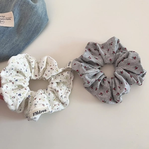 Détail de chouchous floraux en maille avec motif à pois et étiquette de marque