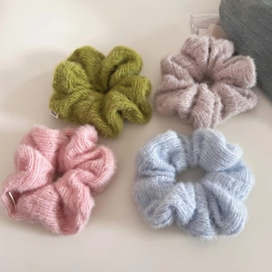 Detailed macro view of soft knit mohair scrunchies in pastel green, pink and blue colors