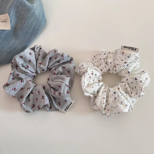 Gros plan de chouchous floraux en maille côtelée aux motifs gris et blancs