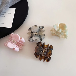 Elegant acetate bow hair claws in four marble patterns with durable metal springs