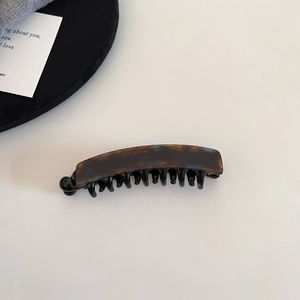 Details der Bananen-Haarspange mit Schildpatt-Muster und schwarzen Greifzähnen