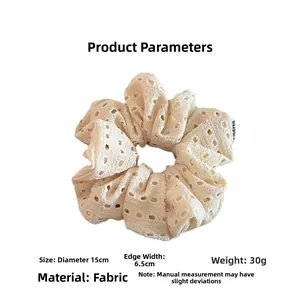 Detail shot of a 15cm oversized off-white lace scrunchie with hollow floral patterns