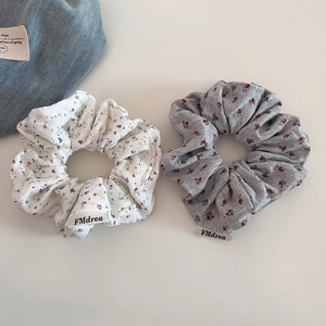 Détail de chouchous fleuris avec texture à côtes verticales et étiquette de marque