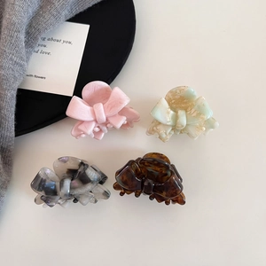 Set of acetate bow hair claws in pink, cream green, marble, and tortoiseshell patterns
