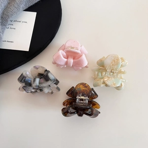 Detail of colorful acetate bow hair clips in pink floral and tortoiseshell patterns