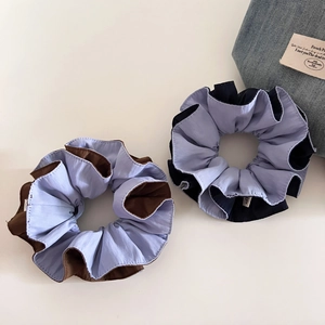 Detail of contrast color fabric hair scrunchies in sky blue and coffee brown tones