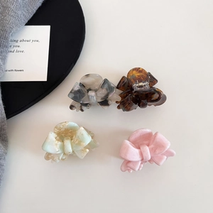 Close-up of acetic acid bow hair clips in tortoiseshell, marble, and pink colors