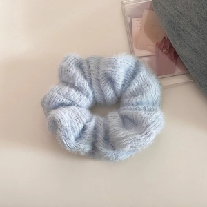 Close-up detail of soft light blue knit hair scrunchie with fluffy mohair-like texture