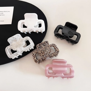 Flat lay of acetate square hair claws in white, black, tortoiseshell and pearl pink
