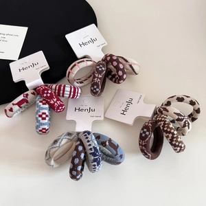 Detail of high-elasticity knitted hair scrunchies with dog jacquard and checkered patterns