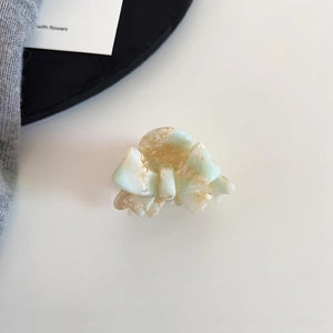 Detail of mint green and cream marble acetate bow hair claw clip for elegant styling