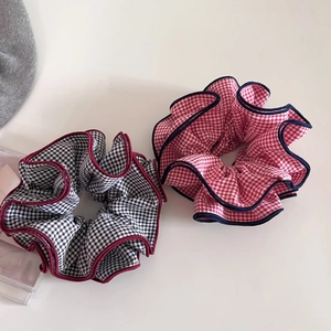 Detailed view of checkered large scrunchies with contrast edges and pleated texture