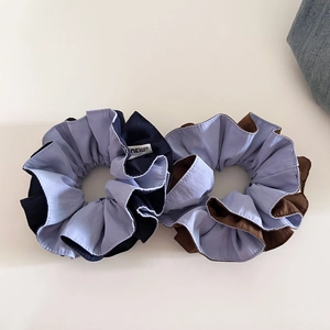 Detail shot of two-tone scrunchies in blue and brown with layered ruffle texture
