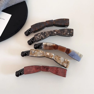 Detailed set of five tortoiseshell acetate banana hair clips with marble patterns