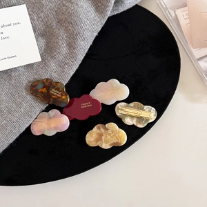 Close-up of cloud-shaped acetate hair clips with France Handmade gold lettering detail