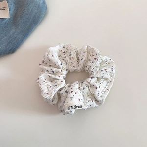 Détail d'un chouchou en maille avec motif floral et texture à côtes verticales