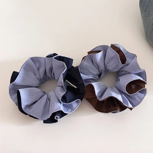 Detail of two-tone large hair scrunchies with matte fabric and multi-layered pleats