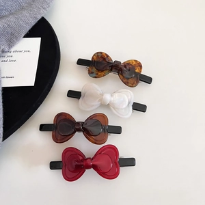 Detailed set of four elegant acetate bow hair clips in tortoiseshell and glossy pearl colors